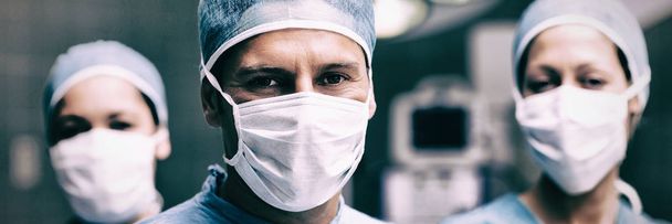 Portrait of male and female doctors standing in operation theater - Foto, immagini