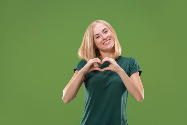 Portrait of attractive cute girl with kiss isolated over green background - Foto, imagen