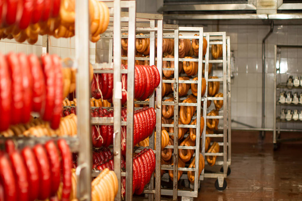 Des saucisses à l'usine de viande. Cuisine industrielle et saucisses fumantes dans une usine de viande
 - Photo, image