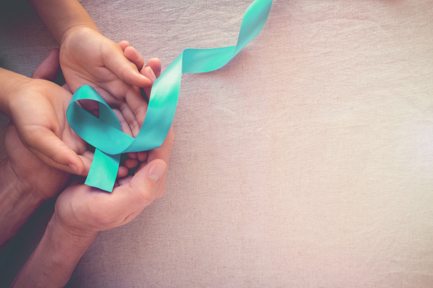 Human hands holding Teal Ribbon. World cancer day. - Foto, immagini