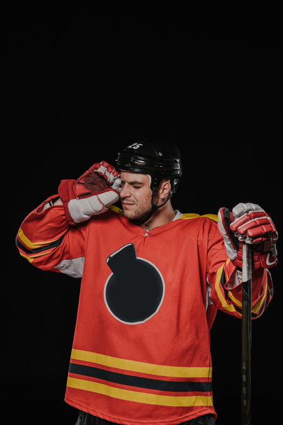 professional hockey player suffering from headache isolated on black - Fotografie, Obrázek