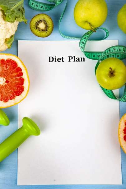 Food and sheet of paper with a diet plan on a blue wooden background. Concept of diet and healthy lifestyle. - Zdjęcie, obraz