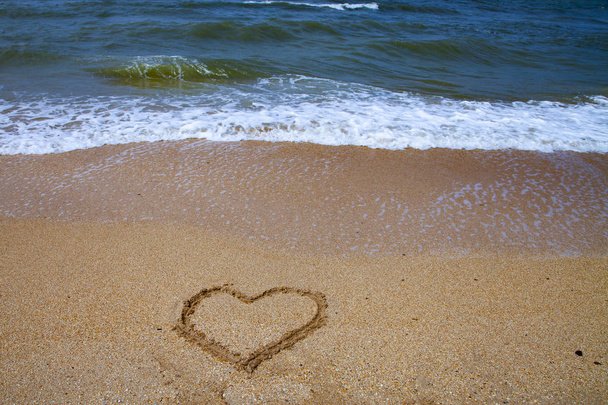Beautiful beach and sea surf. Summer seascape. Heart in the sand and wave close up. - Photo, image