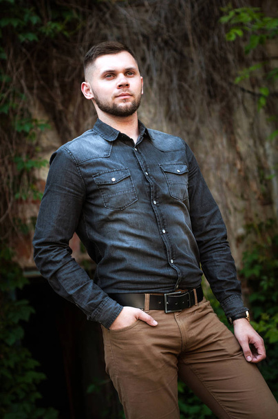 πορτρέτο ενός νεαρού άνδρα σε ένα πουκάμισο και παντελόνι - Φωτογραφία, εικόνα