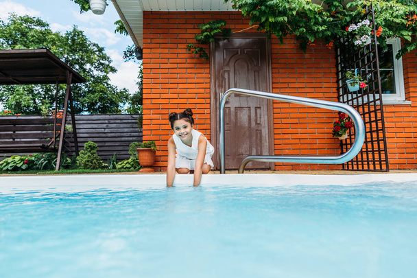 adorável criança sorridente na piscina perto da casa de campo
 - Foto, Imagem