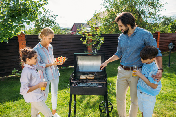 family having barbecue together on backyard on summer day - Photo, Image
