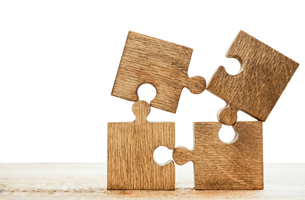 четыре деревянных кусочка головоломки на деревянном фоне. концепция людей, связанных друг с другом
 - Фото, изображение