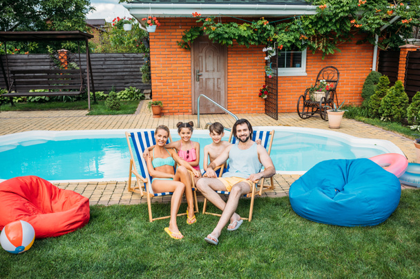 souriant famille passer du temps près de la piscine à la campagne arrière-cour le jour de l'été
 - Photo, image