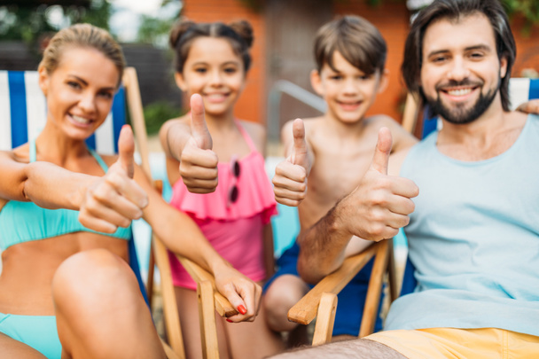 selective focus of family showing thumbs up while spending time near swimming pool on summer day - Photo, Image