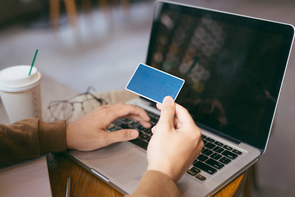 hombre de negocios seguro de compras en línea con tarjeta de crédito utilizando el ordenador portátil en la cafetería
 - Foto, Imagen