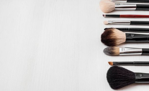 make-up brushes on a light wooden background - 写真・画像