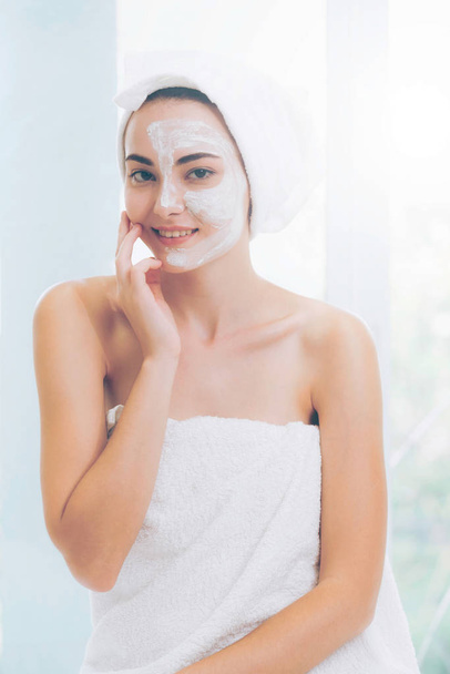 Beautiful woman having a facial cosmetic scrub treatment from professional dermatologist at wellness spa. Anti-aging, facial skin care and luxury lifestyle concept. - Photo, Image