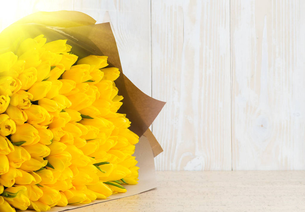 Bouquet of yellow tulips on wooden background gift - Zdjęcie, obraz