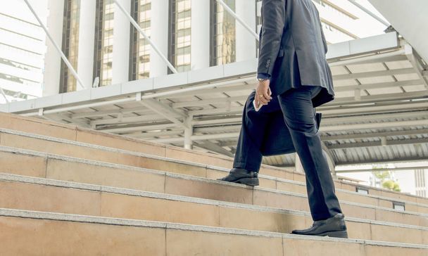 handsome businessman walking or runing on stairs outdoors. - Fotó, kép