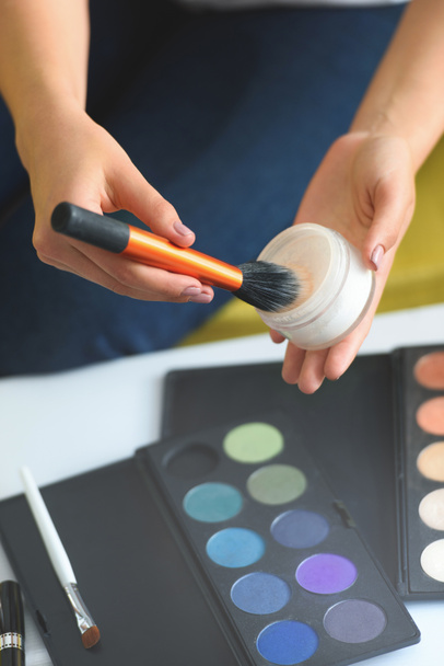 cropped shot of woman holding face powder and makeup brush in hands at home - Photo, Image