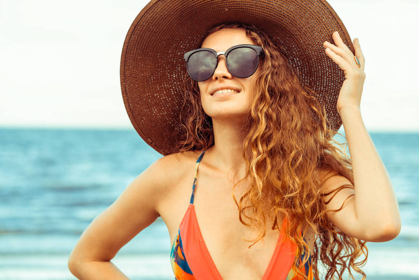 Happy young woman wearing swimsuit having good time at tropical beach in summer for holiday travel vacation. - Photo, Image