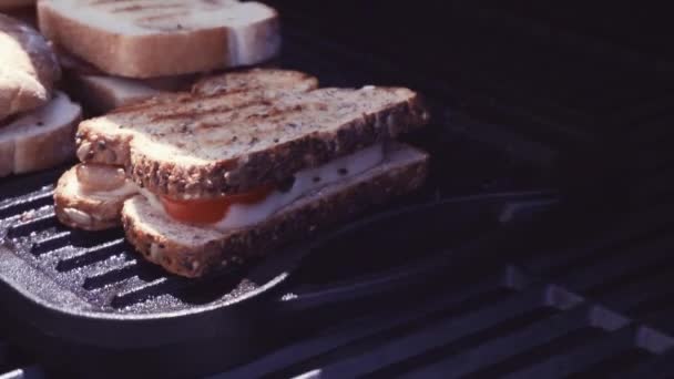 Grillezett sajtos szendvics szalonna csíkokat és friss paradicsom, a szabadtéri gáz grill grillezés - Felvétel, videó