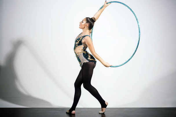 athlete girl playing with hula hoop in studio. - Фото, зображення