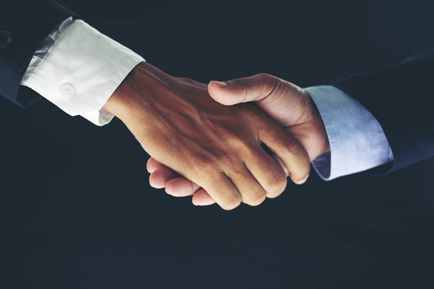 Geschäftspartnerschaftstreffen-Konzept und geschäftlicher Handschlag für ein erfolgreiches Investitionsgeschäft auf schwarzem Hintergrund - Foto, Bild