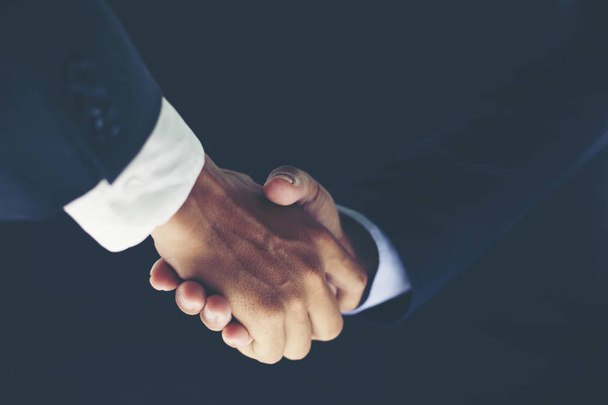 Concept de réunion de partenariat d'affaires et poignée de main d'affaires pour le succès de l'accord d'investissement sur fond noir
 - Photo, image