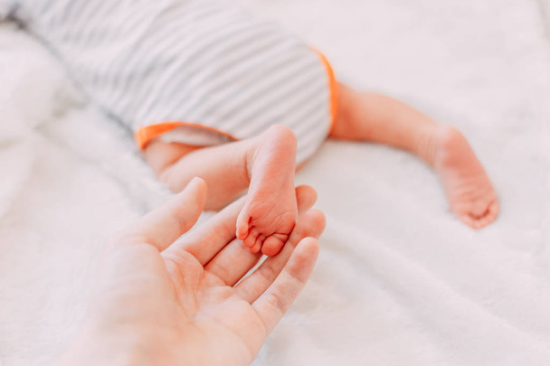 Stopy dziecka w rękach matki. Niemowlęta stopy niemowlęcia na kobiecych kształcie serca ręce zbliżenie. Mama i jej dziecko. Happy Family koncepcji. Piękne koncepcyjne zdjęcie macierzyństwa. - Zdjęcie, obraz