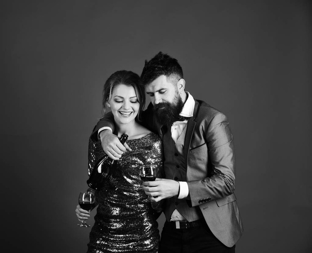 Corporate party concept. Couple in love holding glasses on red background - Фото, изображение