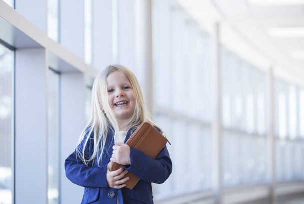 Portrait of lovely little girl laughing in office building - Фото, изображение