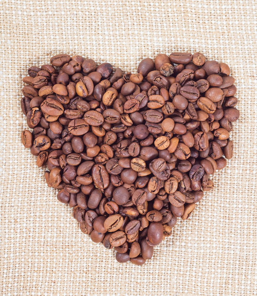 Coffee beans in the form of heart on background of burlap - Photo, Image