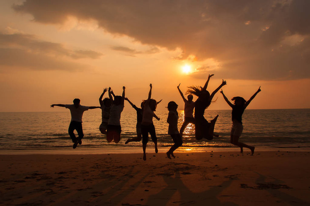 Sylwetka zdjęcie zespołu uroczystości na plaży o zachodzie słońca - Zdjęcie, obraz