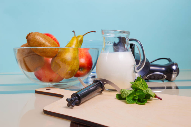 Cooking smoothies on a homemade recipe. Fresh fruits and a blender are on the table - Foto, afbeelding