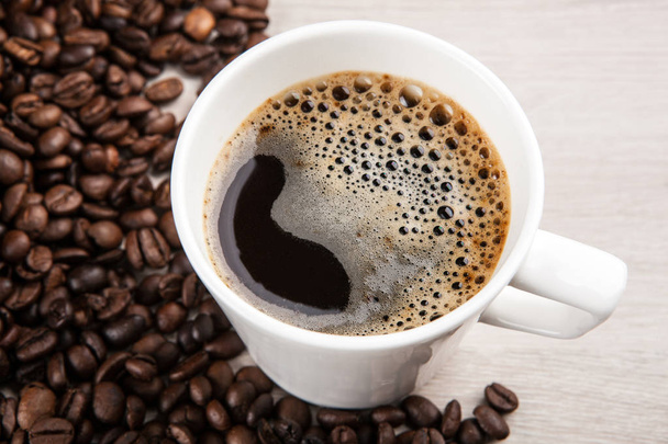 białe filiżanka kawy z pianką na tle smażone ziaren kawy z bliska - Zdjęcie, obraz