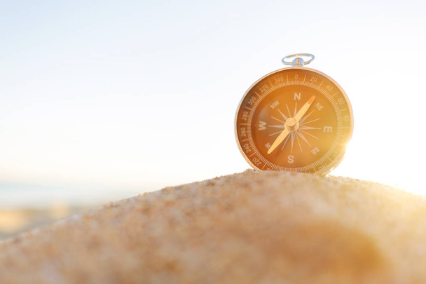 Compass on sand on sunny summer day, concept of travel and vacations. Copy-space in left part of image. - Fotoğraf, Görsel