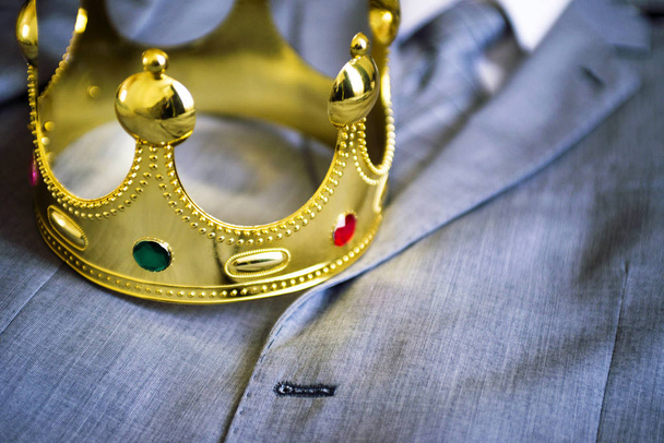 Corona d'oro distesa sul vestito di un uomo d'affari. Concetto aziendale. Metafora
 - Foto, immagini