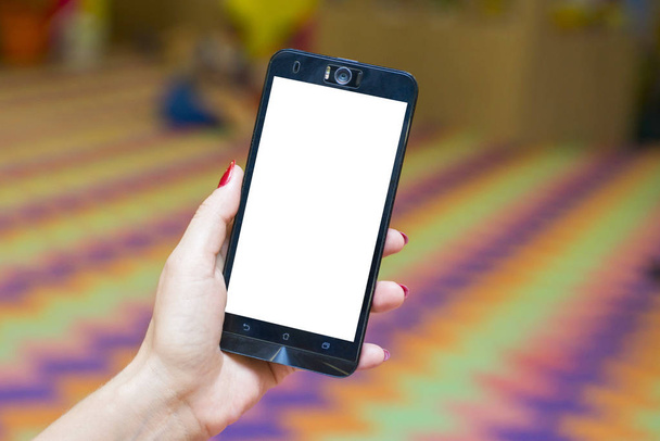 Žena držící chytrý telefon s rozmazané pozadí. Chytrý telefon s prázdnou obrazovkou pro text nebo obsah - Fotografie, Obrázek