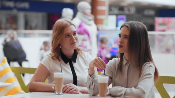 junge Frauen trinken Kaffee und kommunizieren im Café. - Filmmaterial, Video