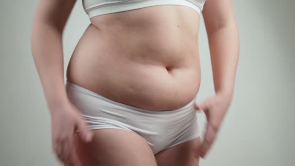 Γυναίκα στο λευκό εσώρουχο κατέχει το λίπος στην κοιλιά. - Πλάνα, βίντεο