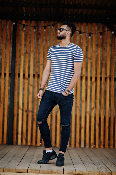 Handsome tall arabian beard man model at stripped shirt posed outdoor. Fashionable arab guy at sunglasses. - Foto, afbeelding