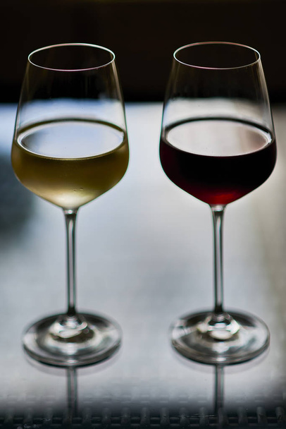 Wysokiej szklanki czerwonego i żółtego wina czarnym tle  - Zdjęcie, obraz