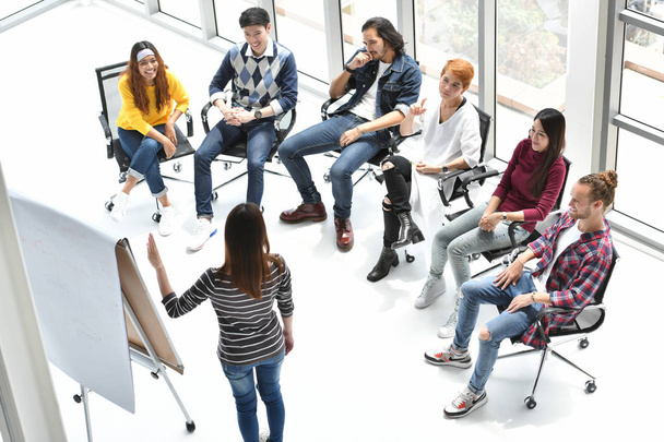 Jovem empresária asiática fazendo apresentação sobre planos futuros para seus colegas no escritório
 - Foto, Imagem
