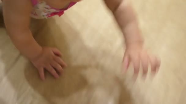 Baby kruipen op houten parketvloer. - Video