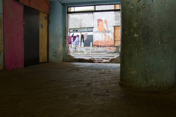 Graffiti pintado en las paredes desgastadas de un edificio condenado utilizado como vivienda
. - Foto, Imagen