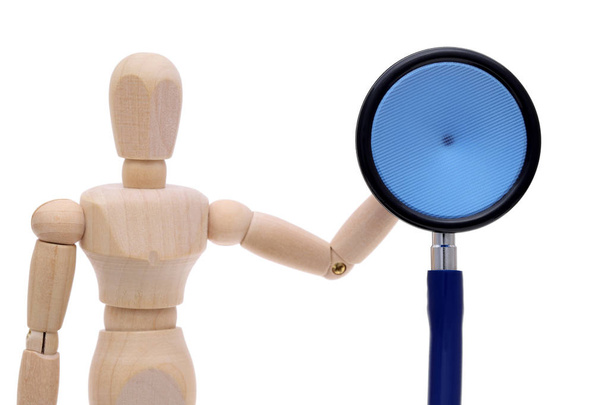 Dřevěné figuríny ruka drží stetoskop, zdravotní vyšetření koncept - Fotografie, Obrázek