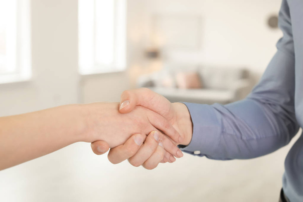 Real estate agent and young man shaking hands indoors, closeup - Foto, Imagem
