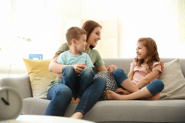 Young woman spending time with her children at home. Happy family - Photo, image