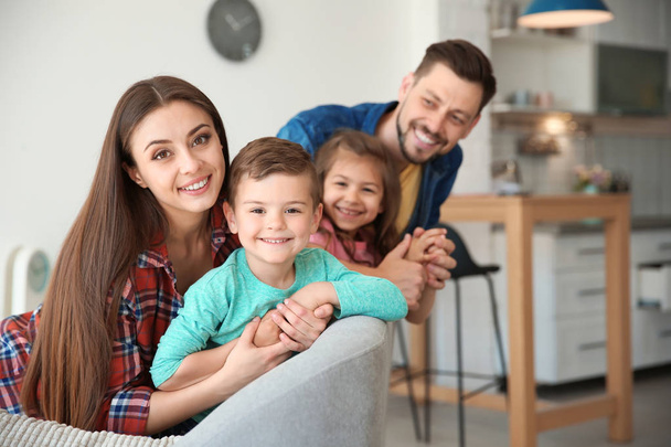 Happy family with cute children on sofa indoors - Valokuva, kuva
