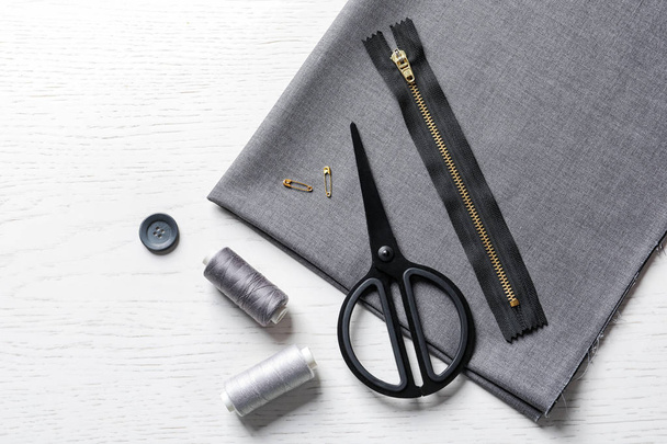 Set of tailoring accessories and fabric on light background, top view - Foto, Imagem