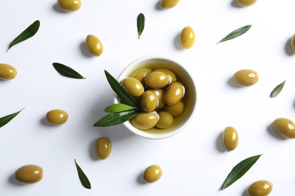Flat lay composition with fresh olives in oil on white background - Фото, зображення