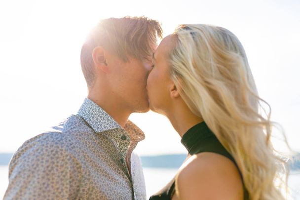 Kissing couple in romantic embrace on beach at summer - Valokuva, kuva
