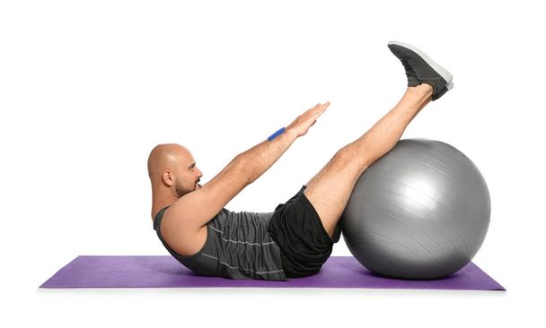 Overweight man doing exercise with fitness ball on white background - Valokuva, kuva