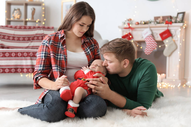 Happy couple with baby celebrating Christmas together at home - Foto, Imagen